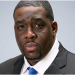 Broderick Bevineau, IT manager and cybersecurity professional, in a black suit and blue tie